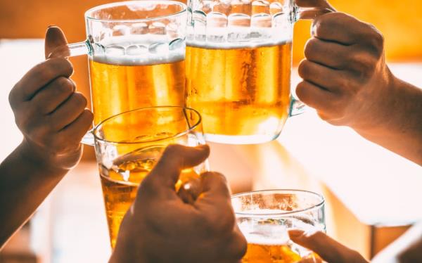 Friends toasting with glasses of light beer at the pub.