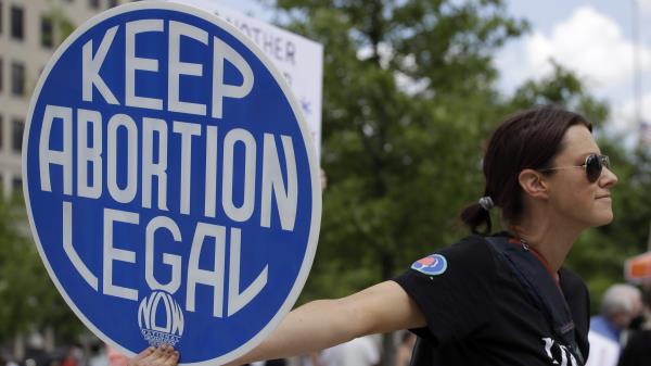 FILE - An abortion-rights demo<em></em>nstrator holds a sign during a rally, May 14, 2022, in Chattanooga, Tenn. On Monday, Jan. 8, 2024, more women joined a Tennessee lawsuit challenging the state's broad abortion ban that went into effect shortly after the U.S. Supreme Court overturned Roe v. Wade in 2022. (AP Photo/Ben Margot, File)