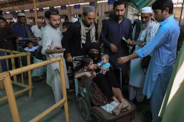 People get their papers checked by the officer while they cross main Afghanistan-Pakistan land border crossing, in Torkham, Pakistan September 15, 2023.