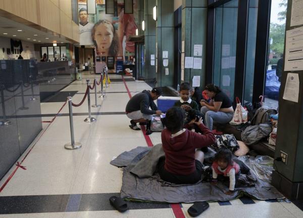 Migrants take shelter inside the Chicago Police Department's 8th District station on Sept. 12, 2023.