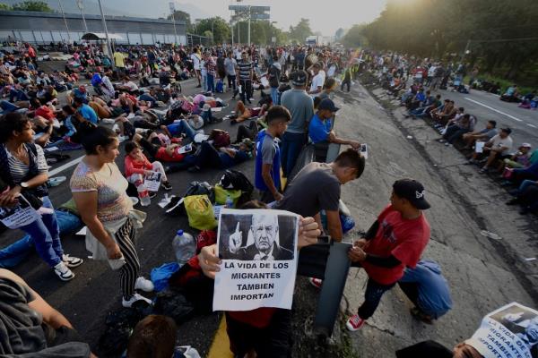 A migrant holds a photo of Mexican President Andrés Manuel López Obrador that reads in Spanish: 