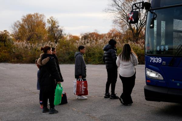 Migrants leave a shelter in Floyd Bennett Field