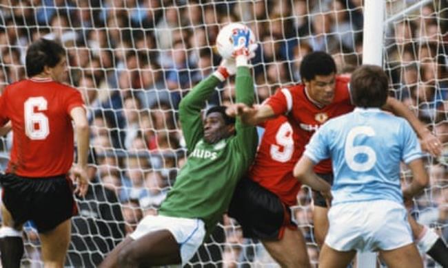 Williams collects the ball under pressure from Paul McGrath during a league match against Manchester United at Maine Road in 1985