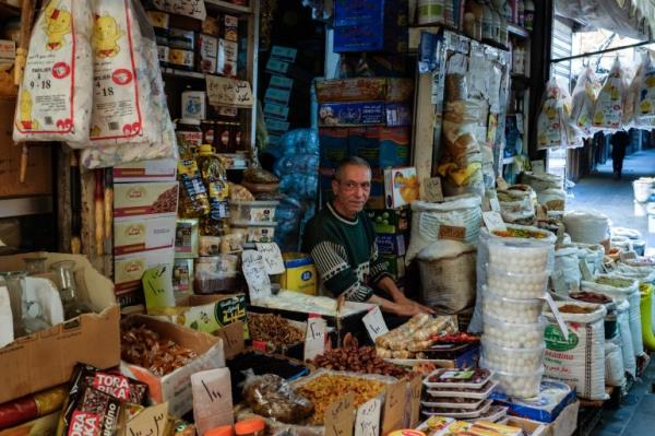 shop owner, older man looking towards the audience