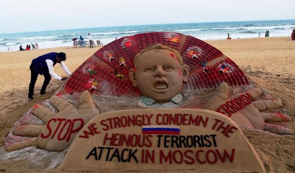 Sand artist Sudarsan Pattnaik gives final touches to a sculpture co<em></em>ndemning the Moscow co<em></em>ncert hall attack at the beach in Puri