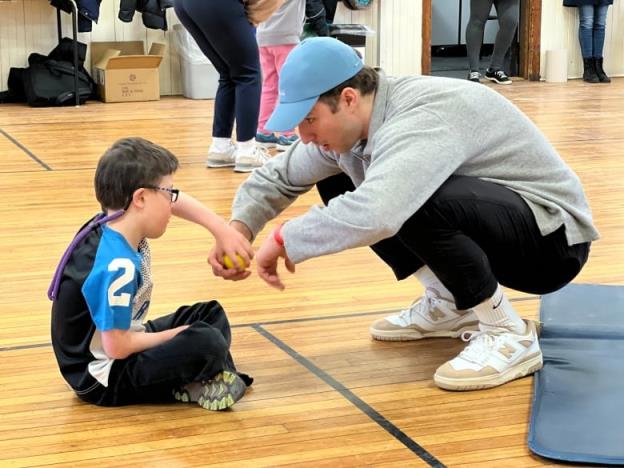 A child and a young man hold on to a ball.