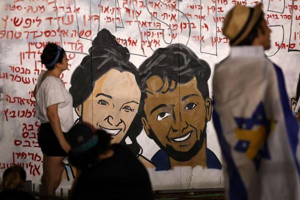 Israeli artists work on a graffiti art work in support of hostages kidnapped during the October 7 attack