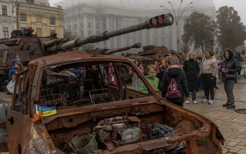 People look at destroyed Russian military vehicles on display in front of Saint Michael's Golden-Domed Mo<em></em>nastery on a foggy day, in Kyiv