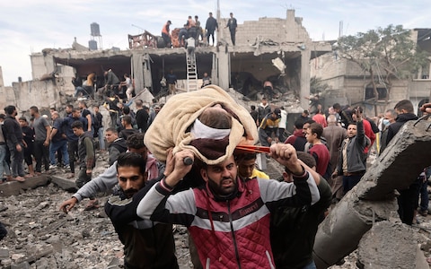 A wounded woman is evacuated following Israeli airstrikes in Khan Younis refugee camp