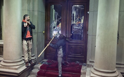 A man tries to break the glass on a door into the city hall