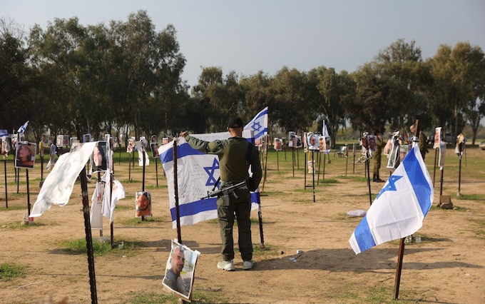 An Israeli soldier pays his respects at the site of the Nova music festival massacre, wher<em></em>e 364 were killed by Hamas